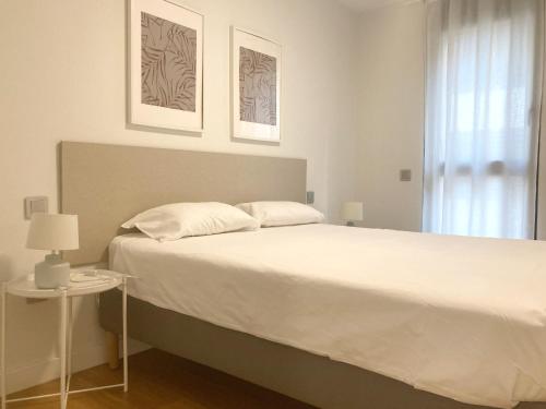 Un dormitorio con una gran cama blanca y una ventana en Luxury Beach Suite by Canary365, en Las Palmas de Gran Canaria