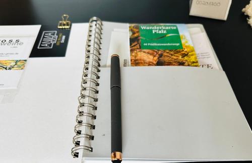 an open spiral notebook with a pen on a desk at ANINA in Meckenheim