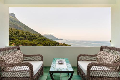 two wicker chairs and a coffee table on a balcony at Santavenere Hotel in Maratea