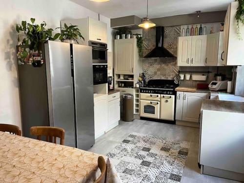 - une cuisine avec des appareils électroménagers blancs et une table dans l'établissement Maison de charme 3 chambres remparts de Guerande, à Guérande