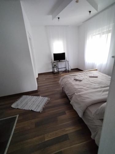 Habitación blanca con cama y escritorio. en Apartament la casa pe Transrarau, en Pojorîta