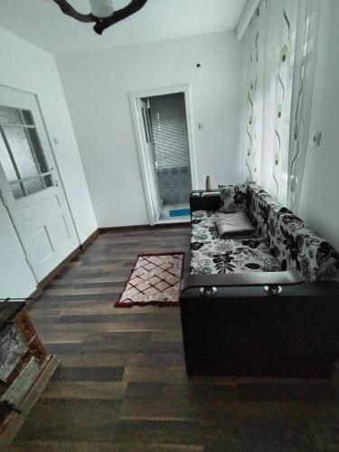 sala de estar con sofá negro y puerta en Apartament la casa pe Transrarau, en Pojorîta