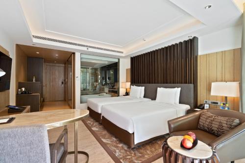 a bedroom with a bed and a couch and a desk at JW Marriott Mussoorie Walnut Grove Resort & Spa in Mussoorie