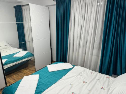 a bedroom with two beds and a mirror at Apartament Central, Năsăud in Năsăud