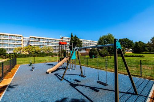 a playground with a slide in a park at Arena Hotel Holiday in Medulin