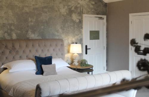 a bedroom with a white bed with a blue pillow at STAY on the High Street in Tarporley