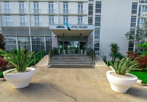 a hotel entrance with plants in front of it at Arena Hotel Holiday in Medulin