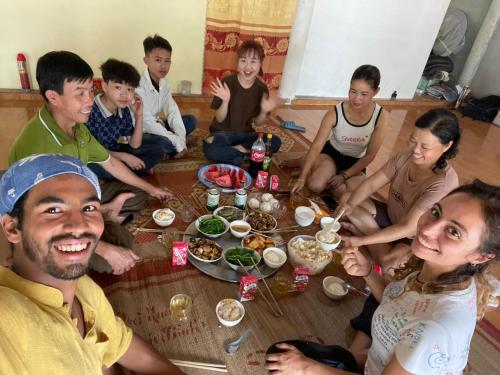 een groep mensen die rond een tafel eten bij Garden Villa Homestay and Tour Motorbike&Car for Rent in Ha Giang