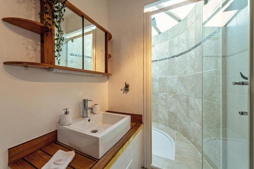 a bathroom with a sink and a glass shower at Maison Rioma - Grande maison à 200m de la plage in Plounéour-Trez