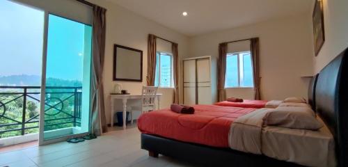 a bedroom with a large bed and a balcony at Rovers Inn Guest House in Tanah Rata