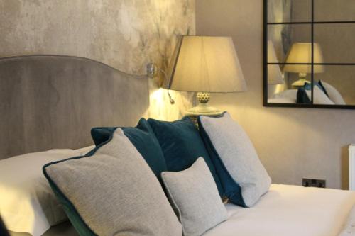 a bedroom with a bed with pillows and a lamp at STAY on the High Street in Tarporley
