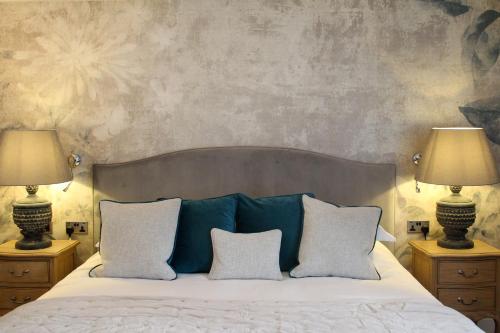 a bedroom with a large bed with two lamps at STAY on the High Street in Tarporley