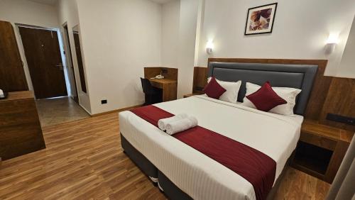 a bedroom with a large bed with red pillows at INDIANA HILLS in Shillong