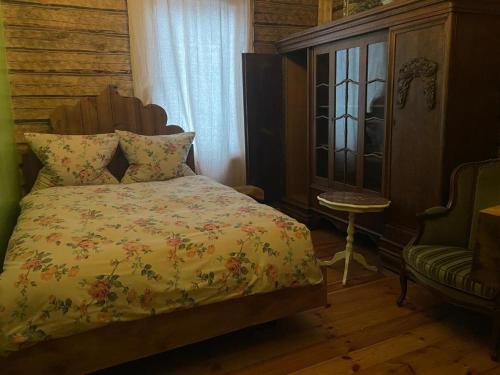 a bedroom with a bed and a chair and a window at Stebuklas in Vilnius