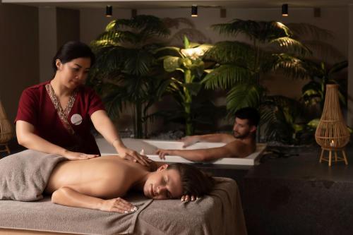 a woman laying on a bed with a woman getting a massage at Miramare Beach Hotel - Ultra All Inclusive in Side