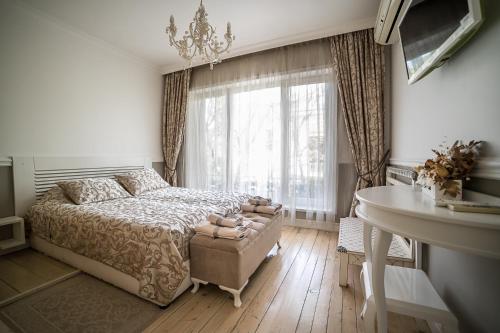 a bedroom with a bed and a desk and a window at Apartment Antique Theatre in Stara Zagora