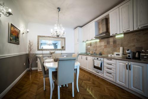 a kitchen with white cabinets and a table and chairs at Apartment Antique Theatre in Stara Zagora