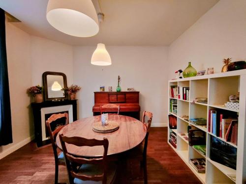 uma sala de jantar com mesa e estantes em Home - Champoulains - Séjour à Auxerre em Auxerre