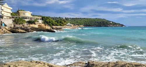 a wave in the ocean next to a beach at Possidon in Agia Marina Aegina