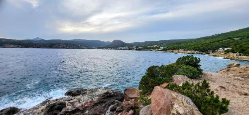 a view of a large body of water with rocks at Possidon in Agia Marina Aegina
