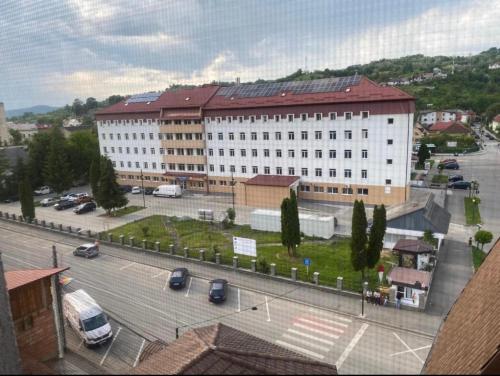 a large building with a parking lot in front of it at Apartament Central, Năsăud in Năsăud
