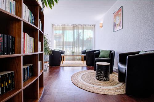 Hotel Centre Plage في أرجيليه سور مير: غرفة معيشة مع كراسي وأرفف كتب