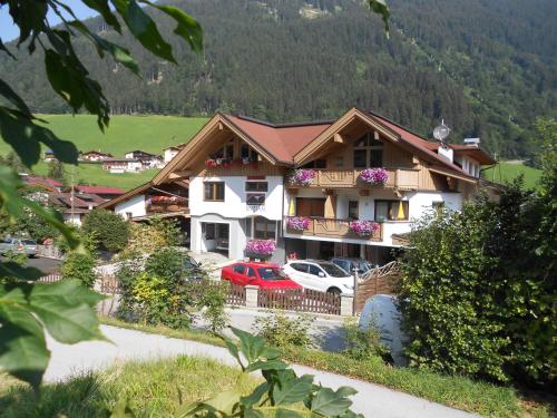 a large building with cars parked in front of it at Appartements Enzian in Finkenberg
