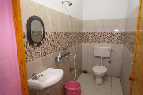a bathroom with a sink and a toilet and a mirror at Hotel Star Lodge Puri in Puri