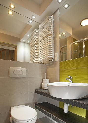 a bathroom with a sink and a toilet and a mirror at Domki apartamenty Nasza Chata - 4 minuty od plaży in Pobierowo