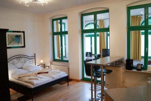 Un dormitorio con una cama, un escritorio y ventanas. en Gemütliche Wohnung für 2 in zentraler Lage, en Heringsdorf