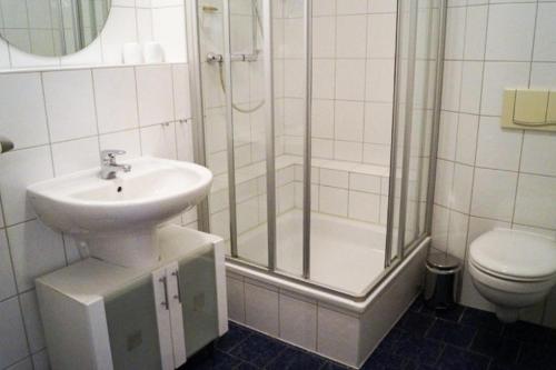 een badkamer met een wastafel, een douche en een toilet bij Gemütliche Wohnung für 2 in zentraler Lage in Heringsdorf