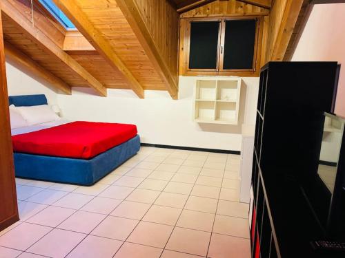 a small room with a bed with a red blanket at La casa di Vale in Arona