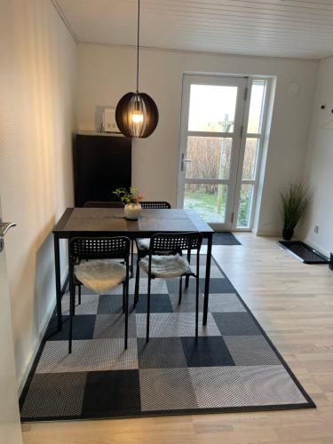 a dining room with a black table and chairs at Værelser i Fynshav in Augustenborg