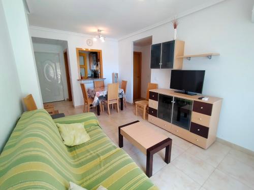 a living room with a couch and a tv at ACV - Jardines del Mar II-2ª linea planta 1 Sur in Oropesa del Mar