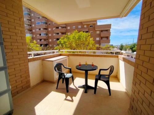 a small balcony with a table and two chairs at ACV - Jardines del Mar II-2ª linea planta 1 Sur in Oropesa del Mar
