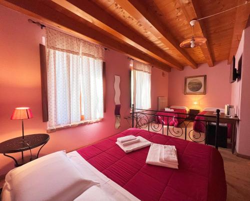 サン・マルティーノ・ブオン・アルベルゴにあるAgriturismo Corte Pellegriniのベッドルーム1室(赤いベッドカバー付きの大型ベッド1台付)