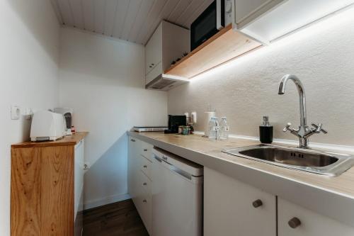 uma cozinha com armários brancos e um lavatório em Quinta de S. Miguel 'Casa Das Oliveiras no Fundão