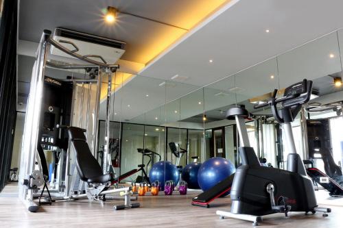 un gimnasio con un montón de equipos de ejercicio y un espejo en Cinnamon Hotel Bangkok en Bangkok