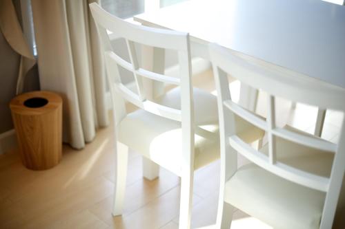 a white table and a chair next to a window at Cinnamon Hotel Bangkok in Bangkok