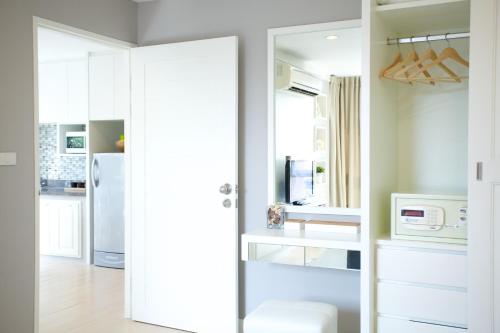 a kitchen with a door open to a kitchen with a refrigerator at Cinnamon Hotel Bangkok in Bangkok