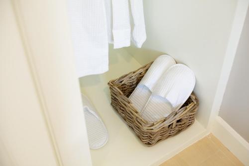 a basket of towels and shoes in a closet at Cinnamon Hotel Bangkok in Bangkok