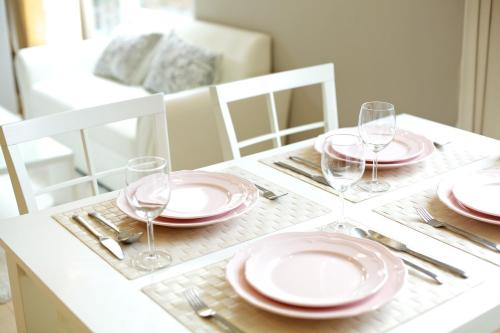 a table with pink plates and wine glasses on it at Cinnamon Hotel Bangkok in Bangkok