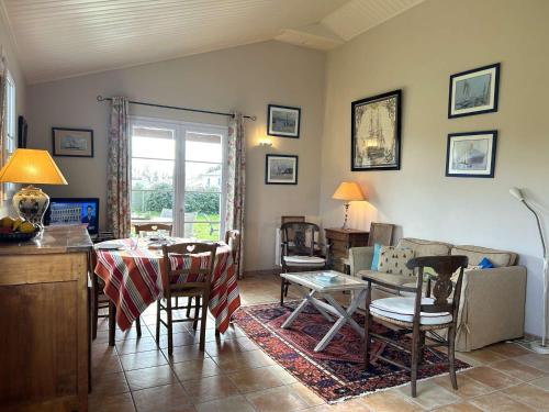 une cuisine et un salon avec une table et des chaises dans l'établissement Maison familiale confortable, 4 couchages, près des plages et commerces, jardin et wifi inclus - FR-1-224-809, à LʼAiguillon-sur-Vie