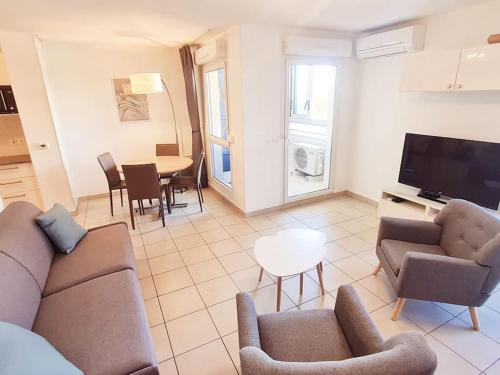 un salon avec un canapé, des chaises et une table dans l'établissement Studio à la mer avec piscine, à Sète