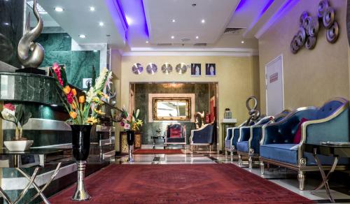 una sala d'attesa con sedie blu e un tappeto rosso di Doha Dynasty Hotel a Doha