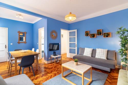 リスボンにあるTelhal by Central Hill Apartmentsの青い壁のリビングルーム(ソファ、テーブル付)