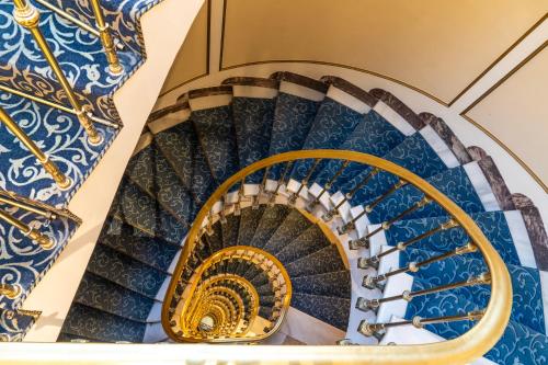 a spiral staircase with blue and gold treads at El Avenida Palace in Barcelona