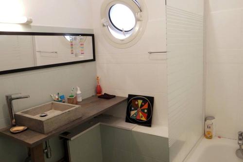 a bathroom with a sink and a mirror and a tub at Villa L'arbre du voyageur -Grande piscine privée vue imprenable sur l'Ocean indien in Saint-Leu