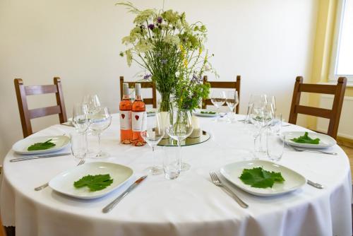 uma mesa com pratos, copos de vinho e flores em Terra Wylak Winery em Veľké Zálužie