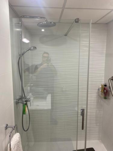 モハカルにあるcasa jewersの浴室のシャワーを撮影する男